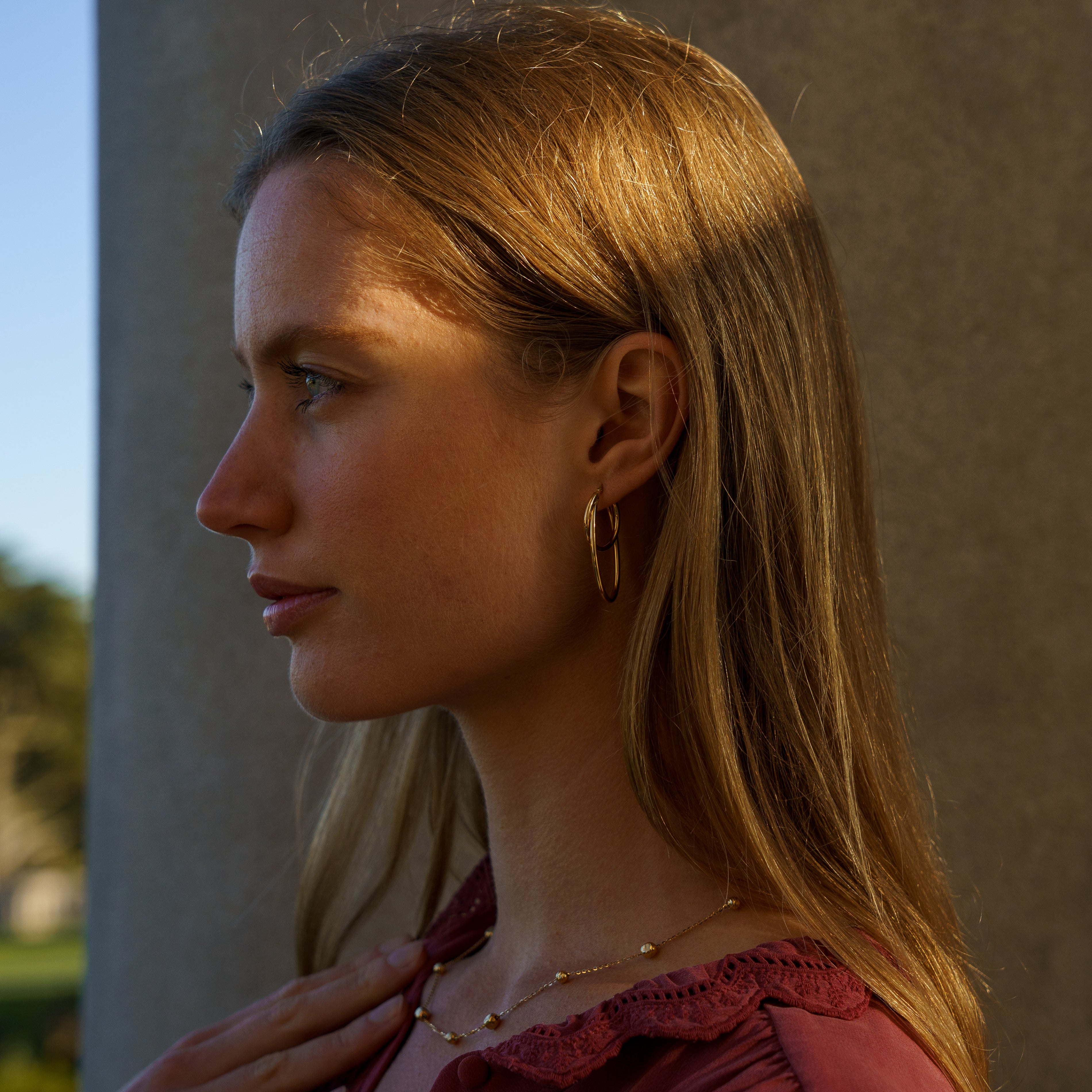 gold bead necklace on model, side angle