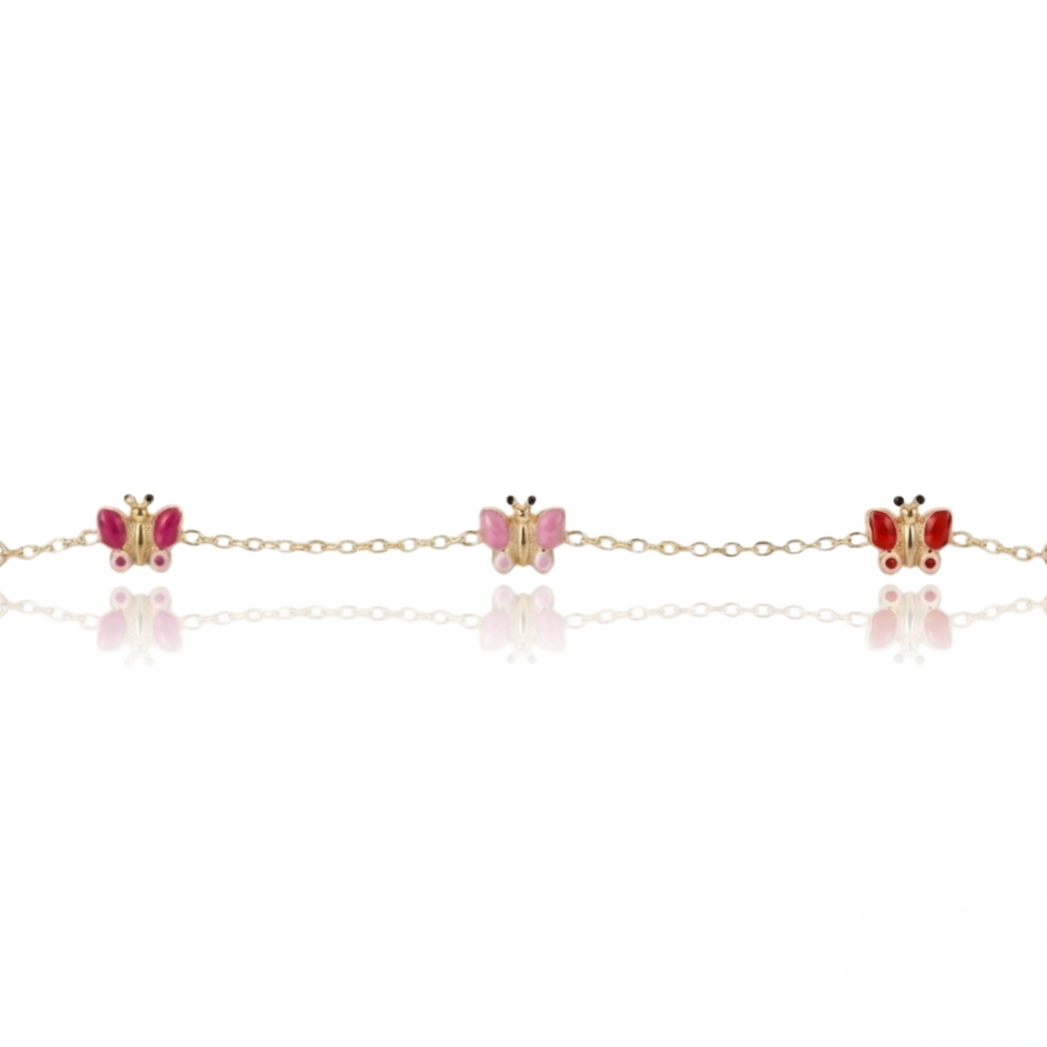 A delicate gold chain bracelet featuring three butterfly charms, with two red butterflies and one pink butterfly, displayed on a clean white background with a soft reflection.
