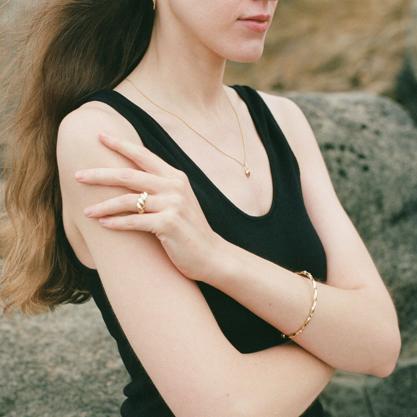 Woman wearing a black sleeveless top with jewelry outdoors