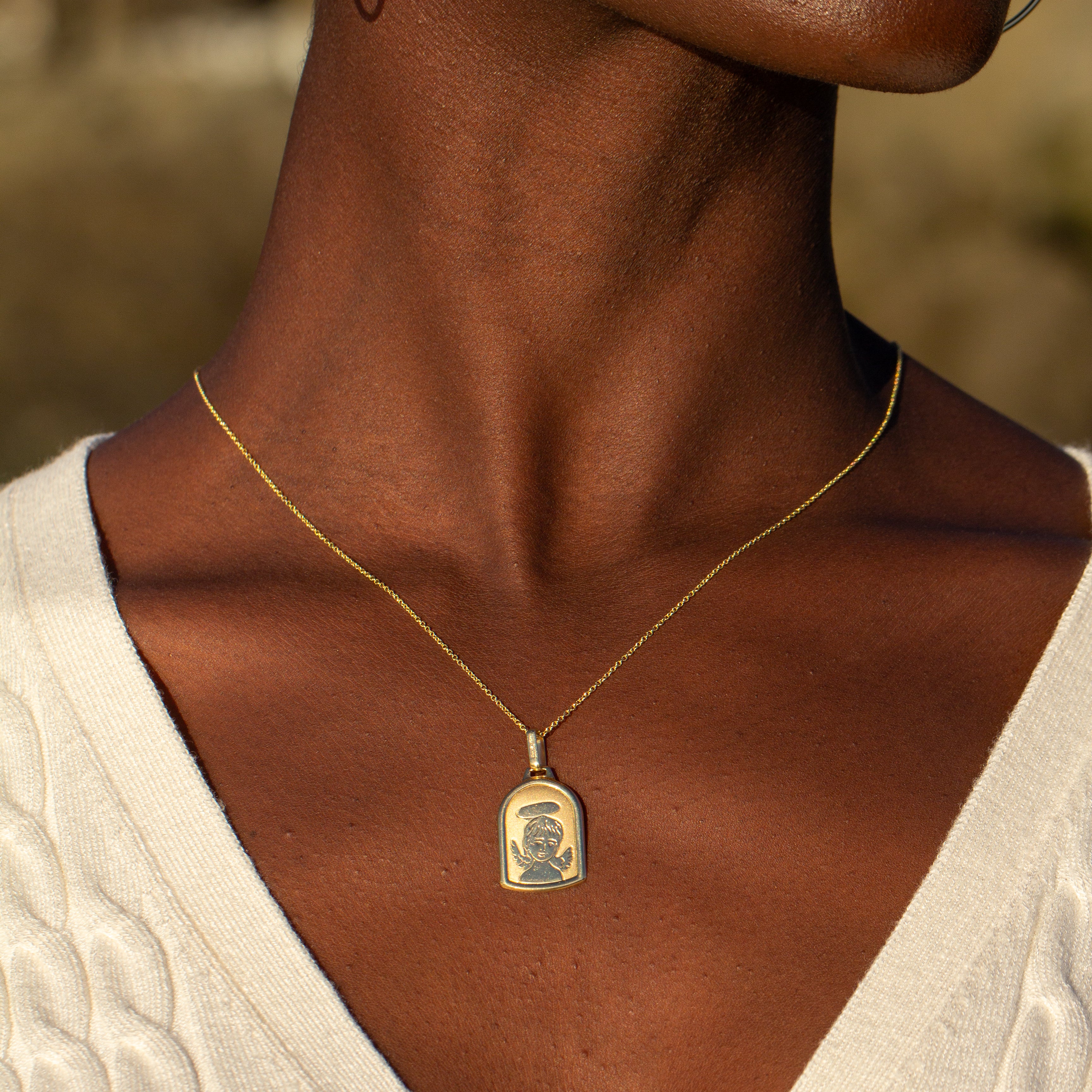 gold angel pendant on model