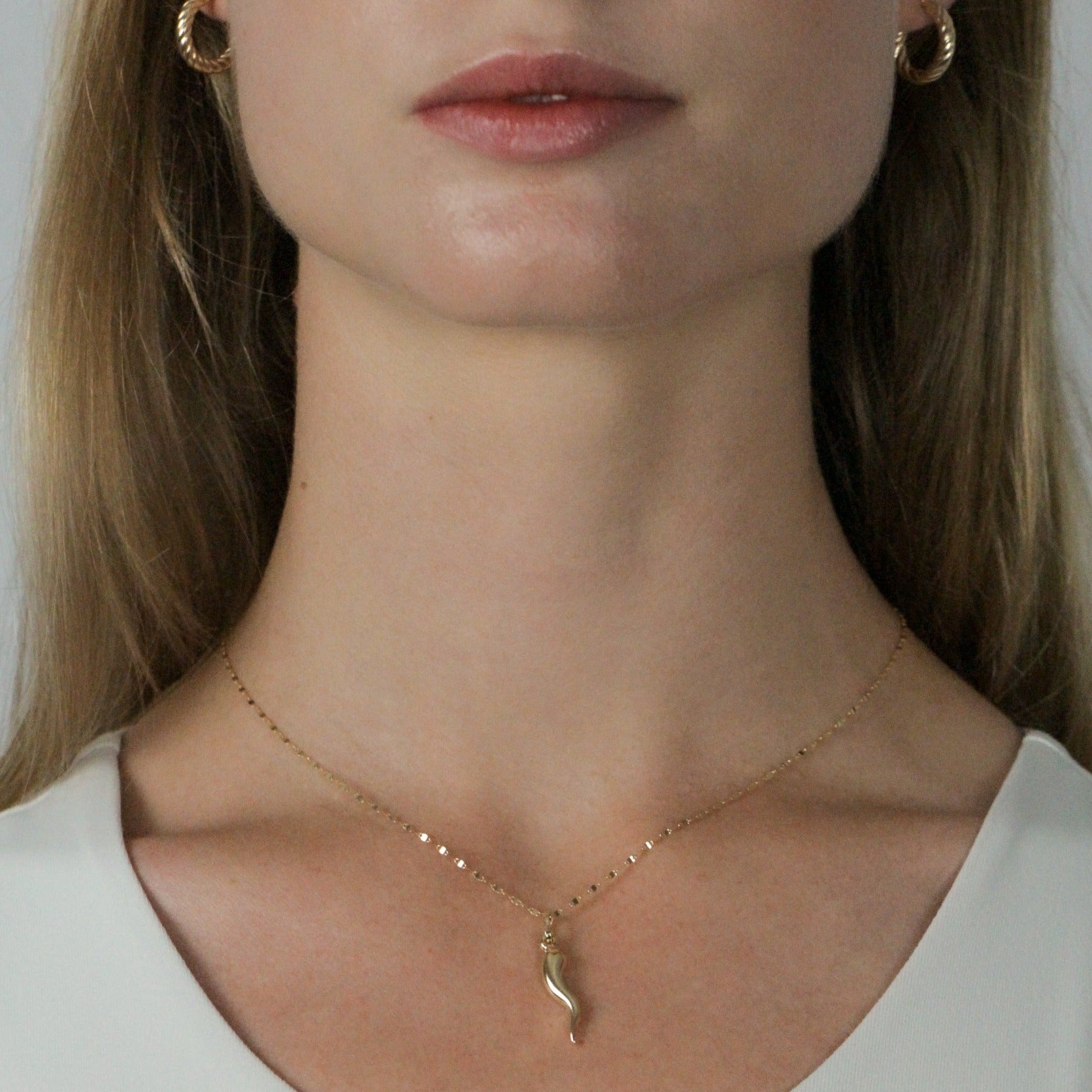gold corno pendant necklace on model