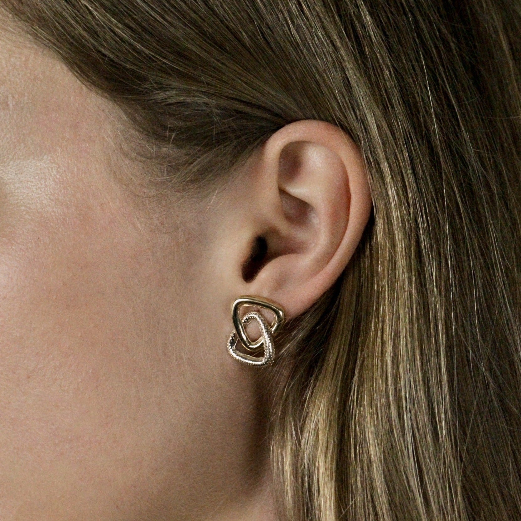 gold stud triangle earrings on model, side angle