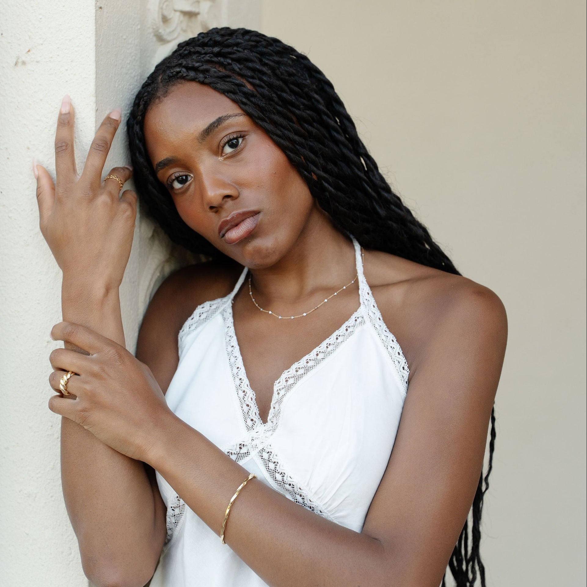 women wearing white halter top with gold jewelry 