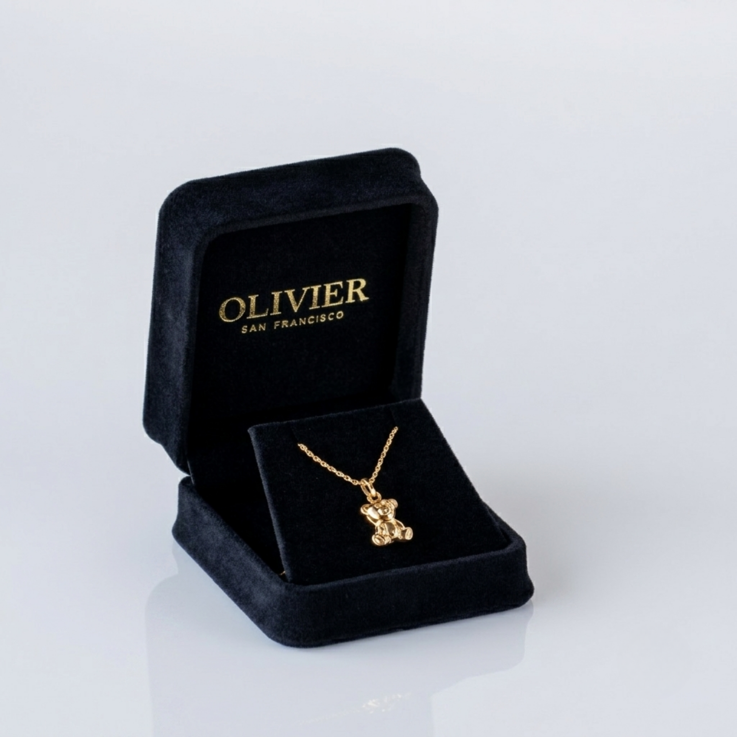 Gold necklace in a black jewelry box with 'Olivier San Francisco' branding on a white background