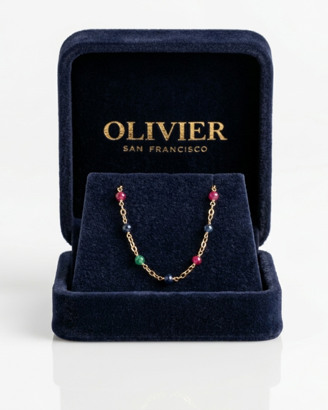 Jewelry box with a gold chain necklace featuring multicolored beads, branded 'Olivier San Francisco'.