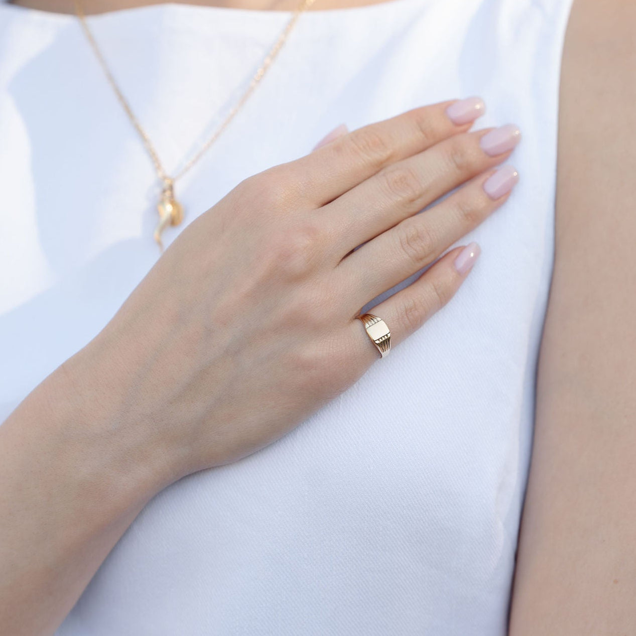 Women wearing square signet ring on white dress